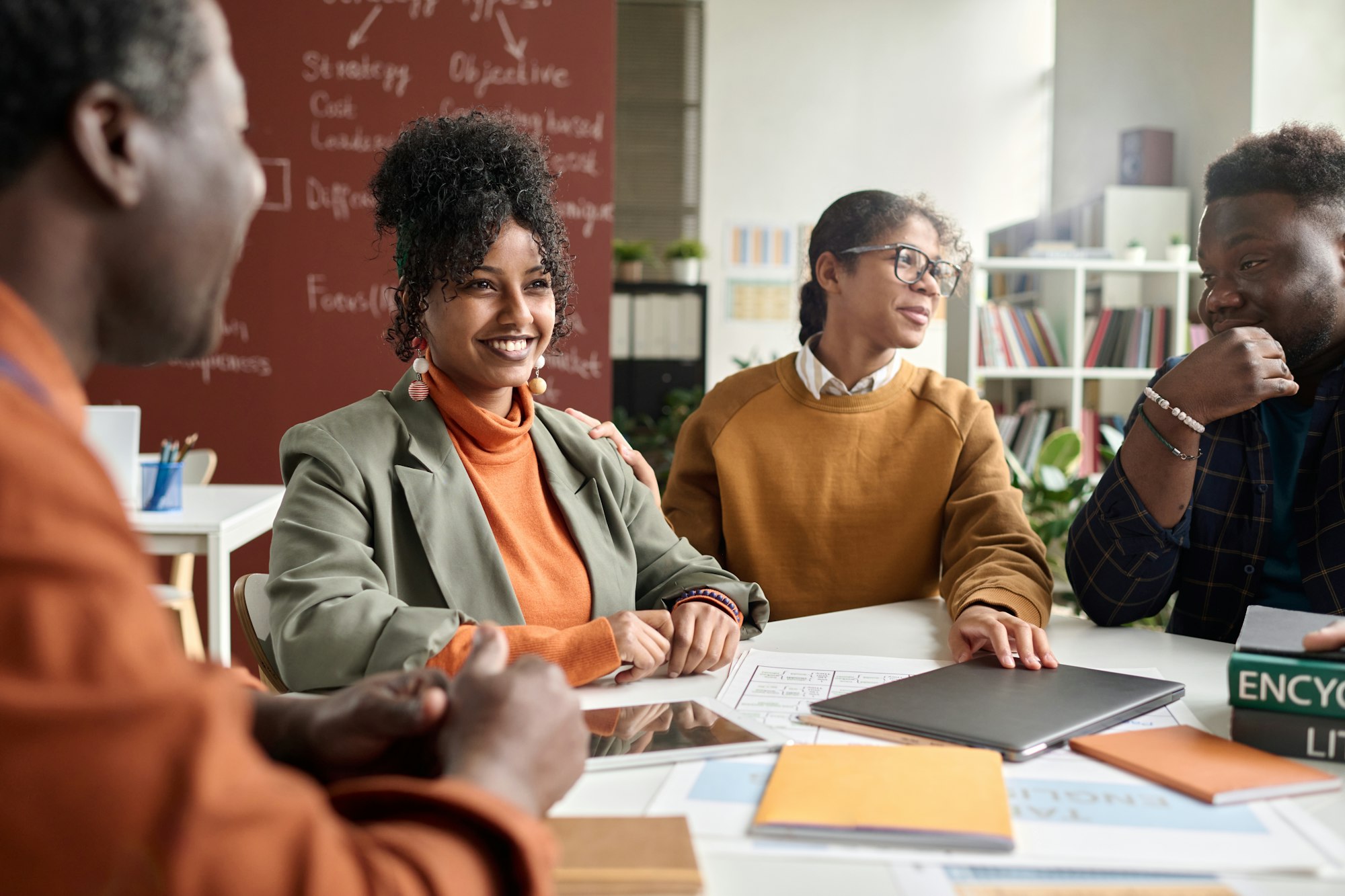 Smiling Curly Haired Girl Enjoying Discussion on Group Project